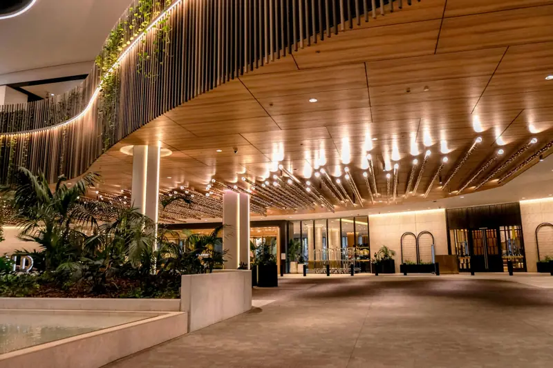 Entrada de un hotel con techo de madera e iluminación cálida